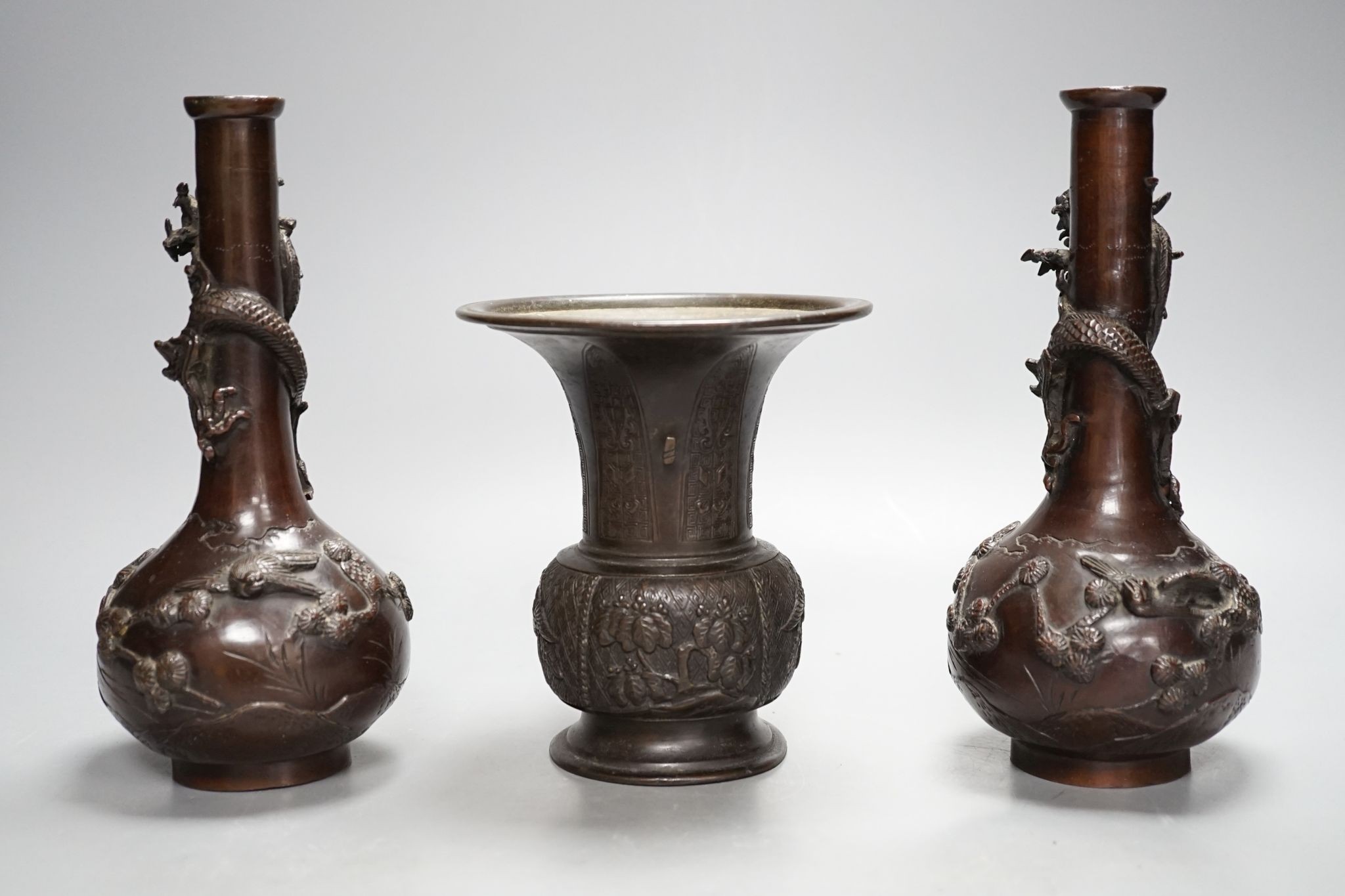 A pair of Japanese Meiji period bronze ‘dragon’ bottle vases and another, 21cm